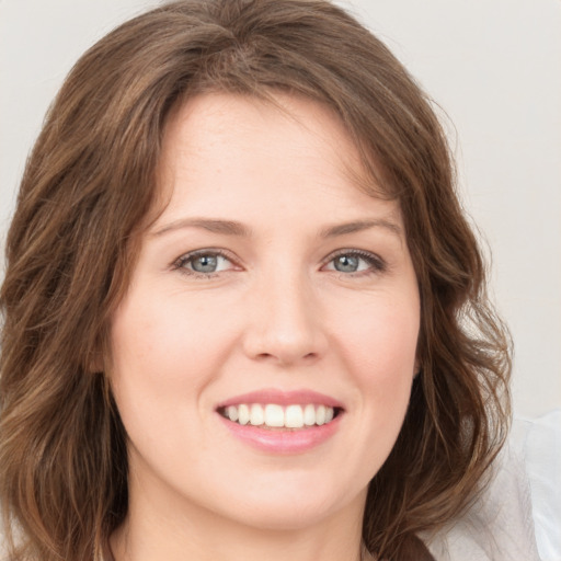 Joyful white young-adult female with long  brown hair and green eyes