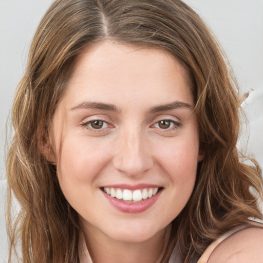 Joyful white young-adult female with long  brown hair and green eyes