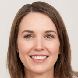 Joyful white young-adult female with long  brown hair and green eyes