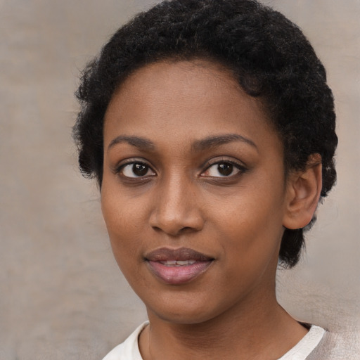 Joyful black young-adult female with short  brown hair and brown eyes