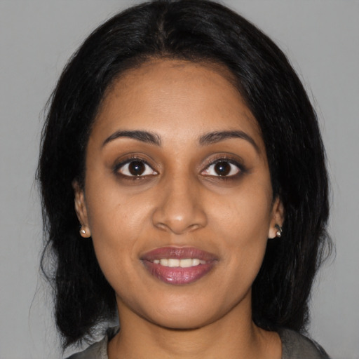 Joyful black young-adult female with medium  black hair and brown eyes