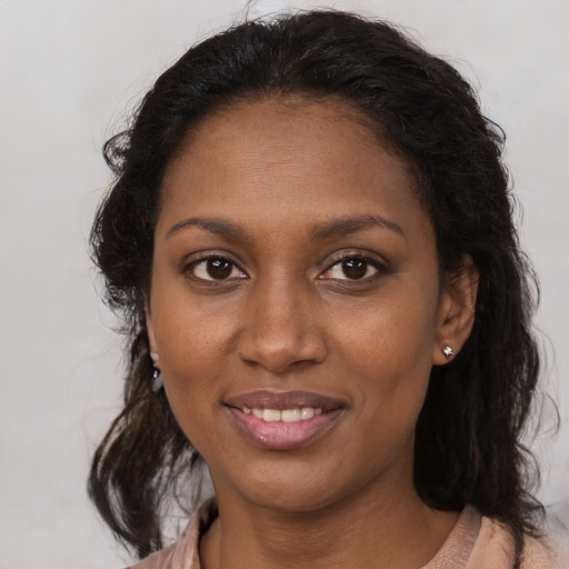 Joyful black young-adult female with long  brown hair and brown eyes