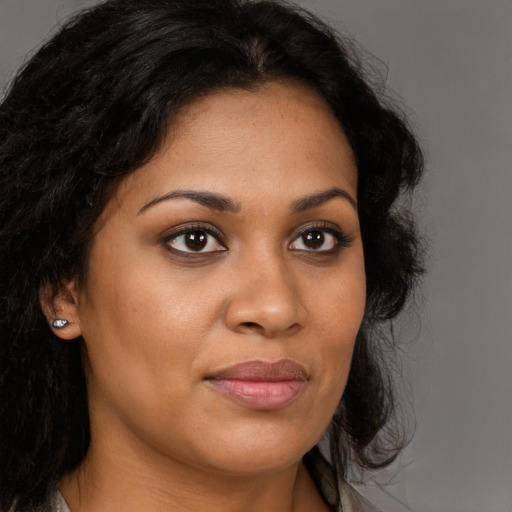 Joyful black young-adult female with long  brown hair and brown eyes