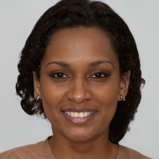 Joyful black young-adult female with medium  brown hair and brown eyes