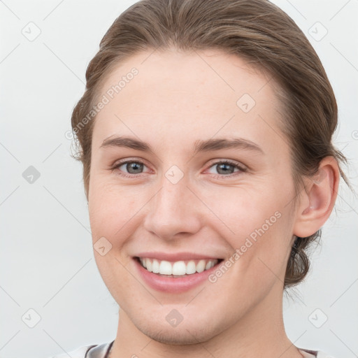 Joyful white young-adult female with short  brown hair and grey eyes