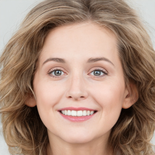 Joyful white young-adult female with long  brown hair and green eyes