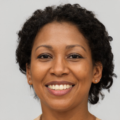 Joyful black adult female with short  brown hair and brown eyes