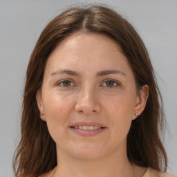 Joyful white adult female with long  brown hair and grey eyes