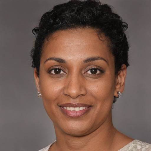 Joyful black young-adult female with short  black hair and brown eyes