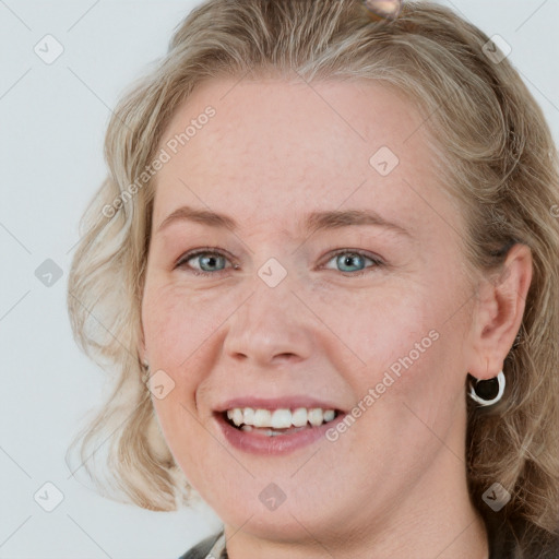 Joyful white young-adult female with medium  brown hair and blue eyes