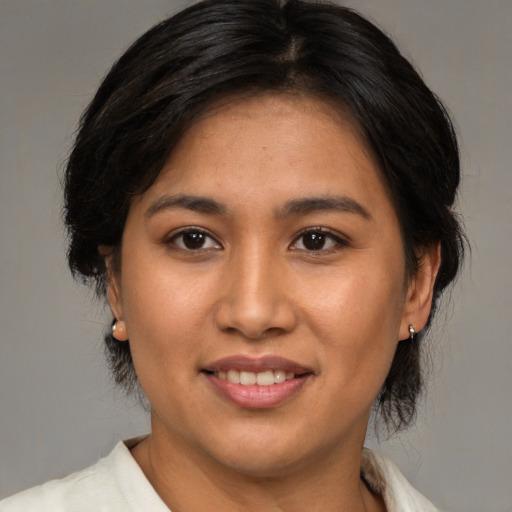 Joyful asian young-adult female with medium  brown hair and brown eyes