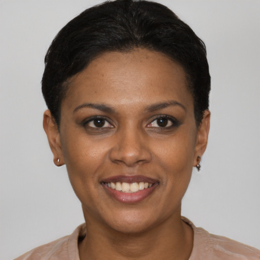 Joyful black young-adult female with short  black hair and brown eyes