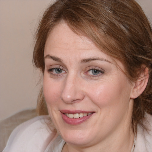 Joyful white adult female with medium  brown hair and blue eyes