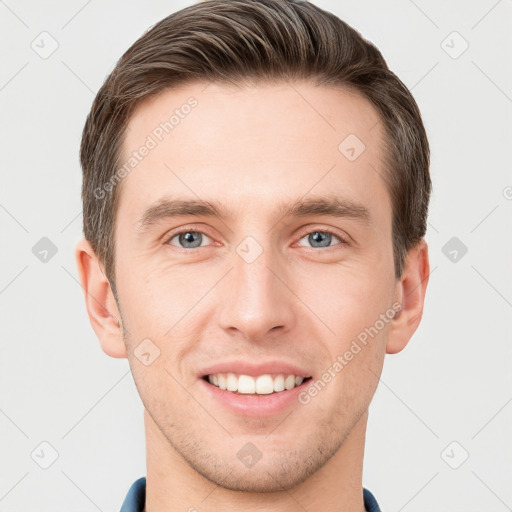 Joyful white young-adult male with short  brown hair and grey eyes