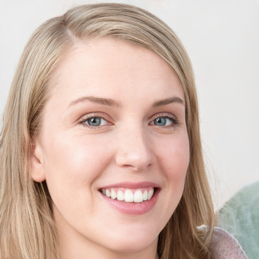 Joyful white young-adult female with long  brown hair and blue eyes