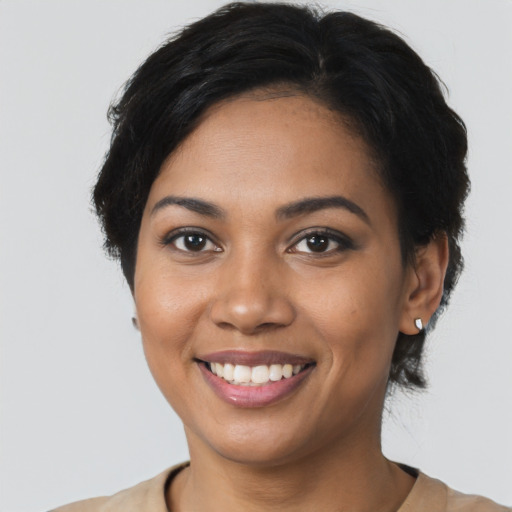 Joyful black young-adult female with short  black hair and brown eyes