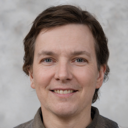 Joyful white adult male with short  brown hair and grey eyes