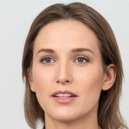 Joyful white young-adult female with medium  brown hair and grey eyes