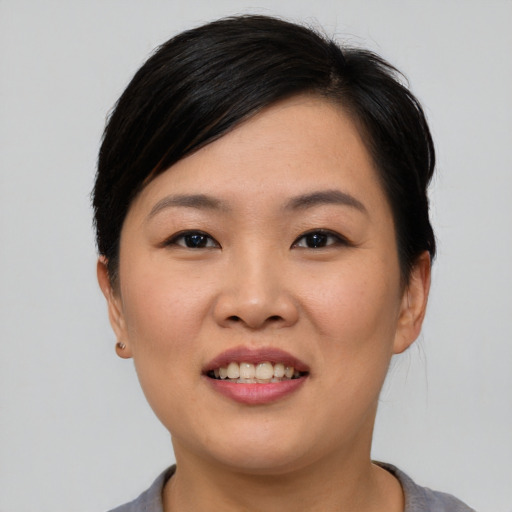 Joyful asian young-adult female with short  black hair and brown eyes