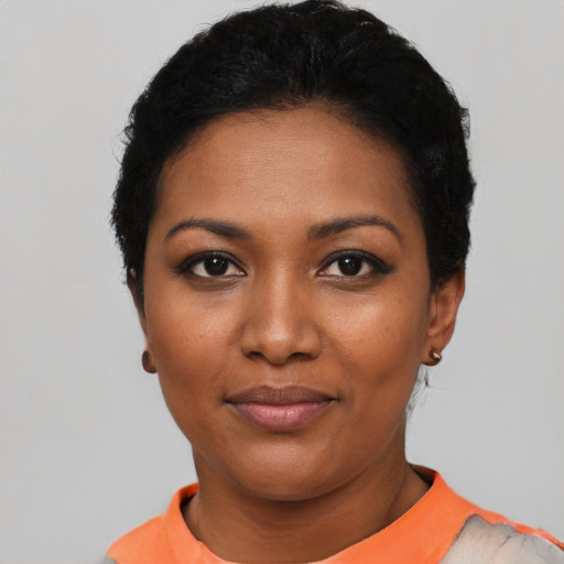 Joyful black young-adult female with short  black hair and brown eyes