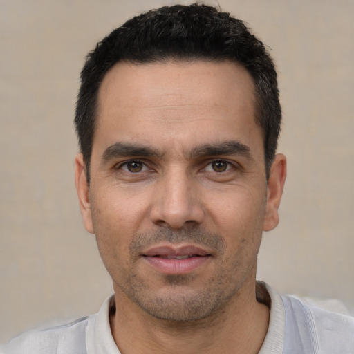 Joyful white adult male with short  black hair and brown eyes