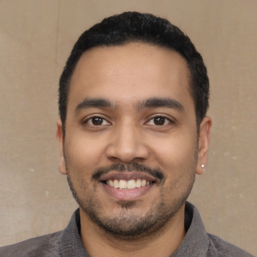 Joyful latino young-adult male with short  black hair and brown eyes