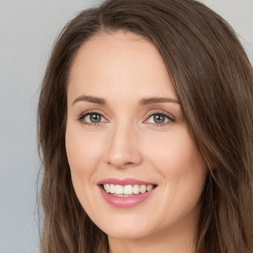 Joyful white young-adult female with long  brown hair and green eyes