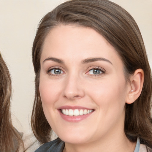 Joyful white young-adult female with medium  brown hair and blue eyes