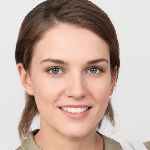 Joyful white young-adult female with medium  brown hair and grey eyes