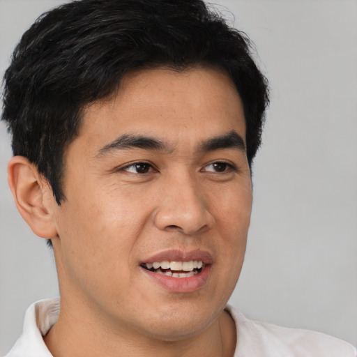 Joyful latino young-adult male with short  brown hair and brown eyes
