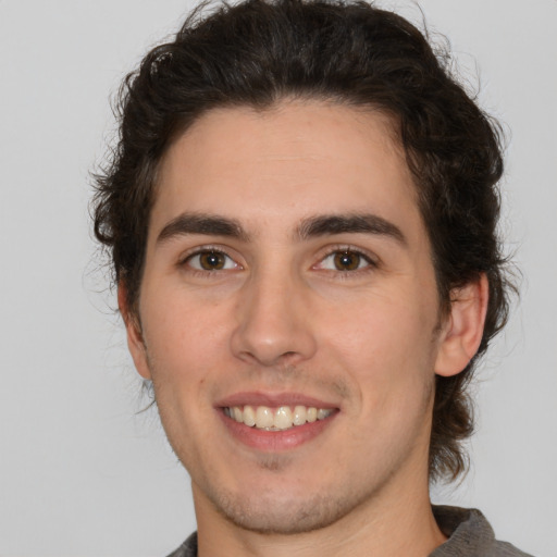 Joyful white young-adult male with medium  brown hair and brown eyes