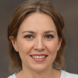 Joyful white adult female with medium  brown hair and brown eyes