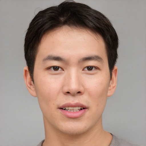 Joyful asian young-adult male with short  brown hair and brown eyes