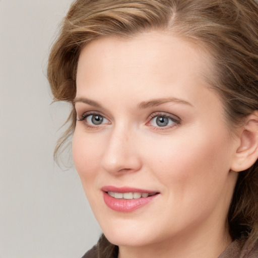 Joyful white young-adult female with long  brown hair and blue eyes