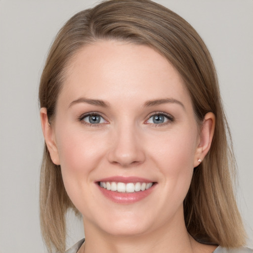 Joyful white young-adult female with medium  brown hair and grey eyes