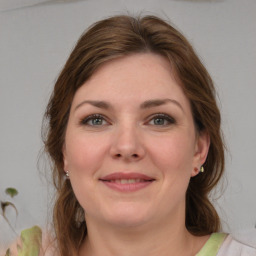 Joyful white young-adult female with medium  brown hair and green eyes