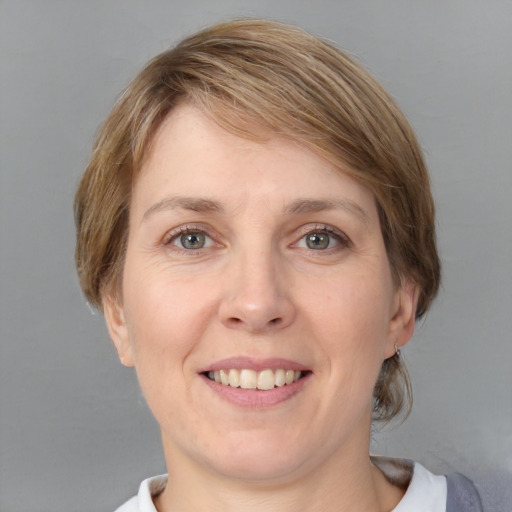 Joyful white adult female with medium  brown hair and grey eyes