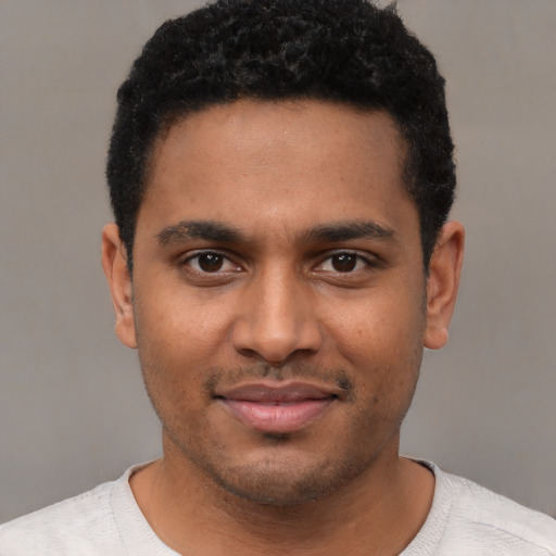 Joyful black young-adult male with short  black hair and brown eyes