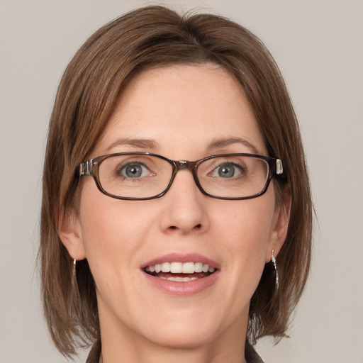 Joyful white adult female with medium  brown hair and blue eyes