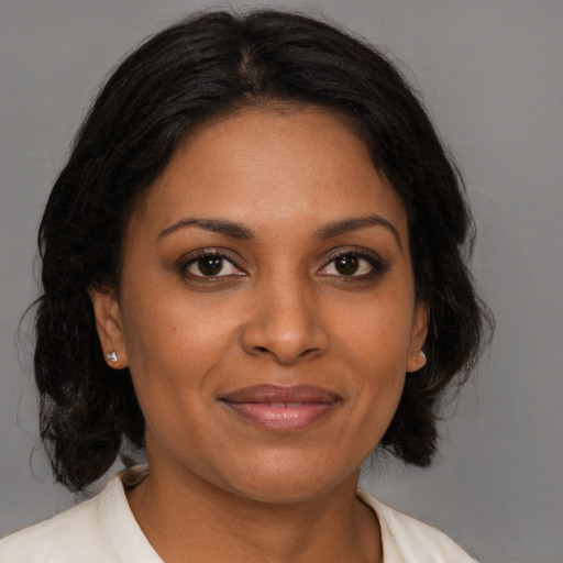 Joyful black adult female with medium  brown hair and brown eyes