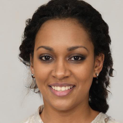 Joyful black young-adult female with long  brown hair and brown eyes