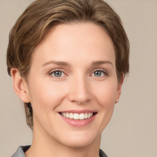 Joyful white young-adult female with short  brown hair and grey eyes