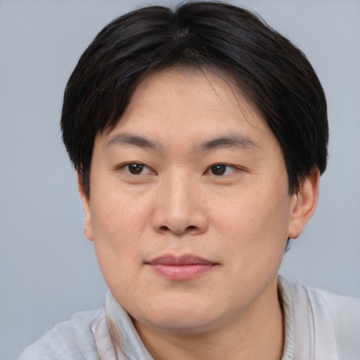 Joyful asian young-adult male with short  brown hair and brown eyes
