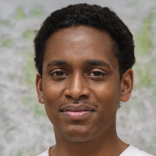 Joyful black young-adult male with short  black hair and brown eyes
