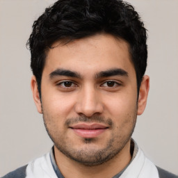 Joyful white young-adult male with short  black hair and brown eyes