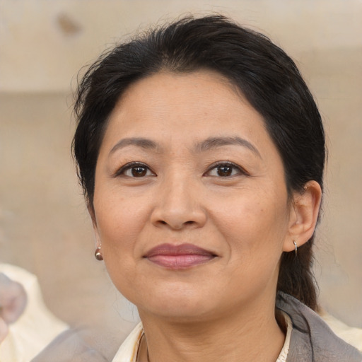 Joyful asian adult female with medium  brown hair and brown eyes