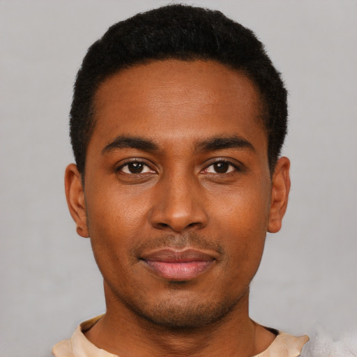 Joyful black young-adult male with short  black hair and brown eyes
