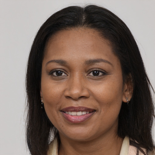 Joyful black adult female with long  brown hair and brown eyes