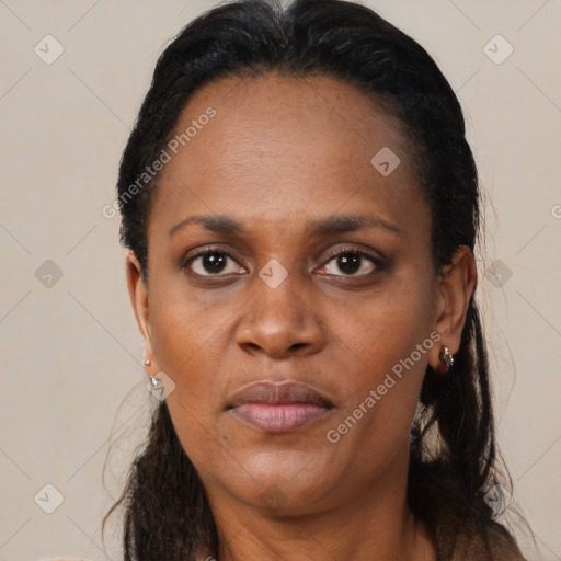 Joyful black adult female with long  brown hair and brown eyes