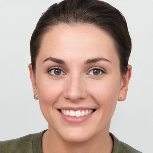 Joyful white young-adult female with short  brown hair and grey eyes